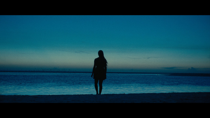 Woman silhouette on beach, still from It's Snowing Outside short film